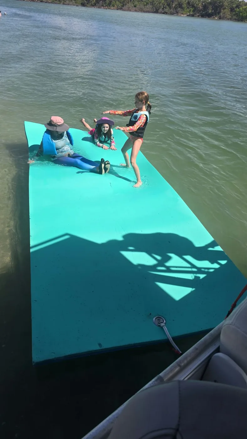 Family enjoying the floating water mat