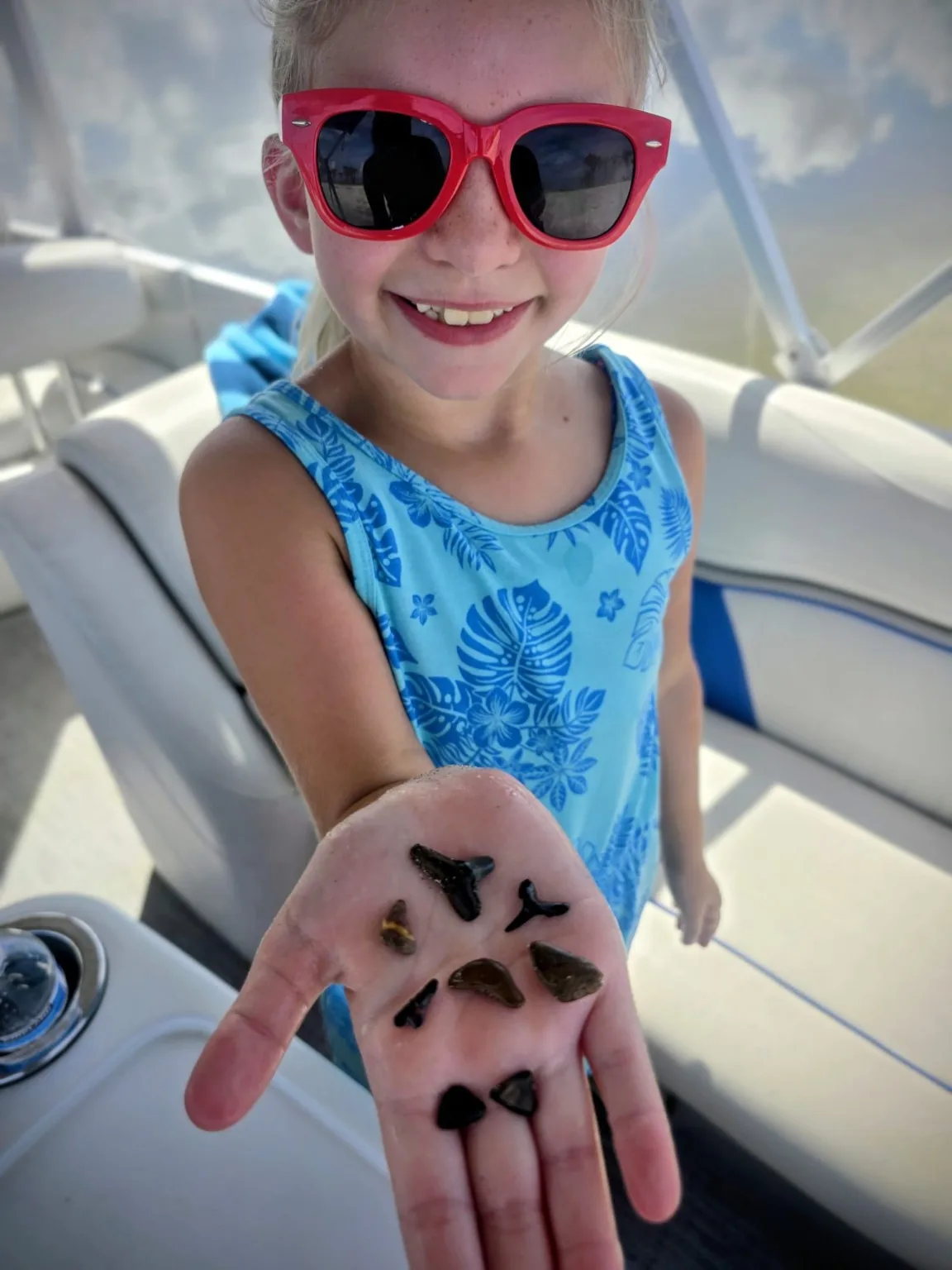 Young guest showing shark teeth found during an Aquaholic Venice cruise