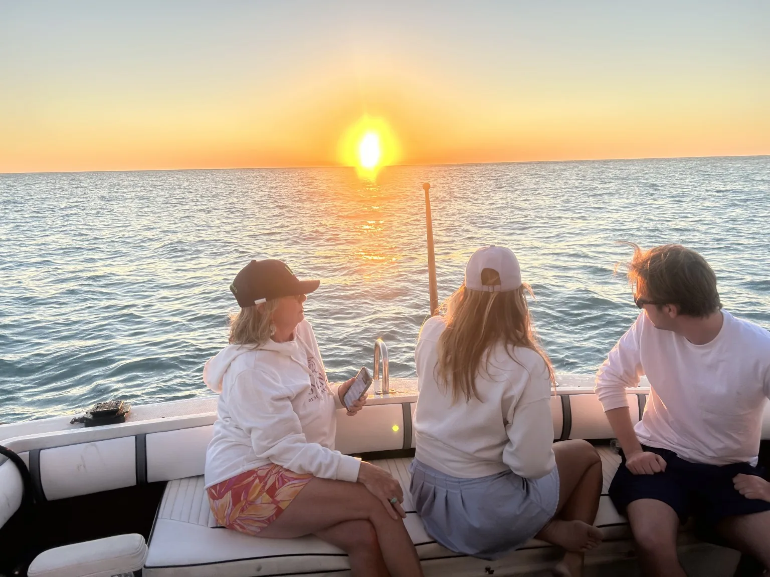 Guests relaxing aboard Aquaholic Charters during a Gulf Coast sunset